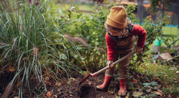 Kinde mit Schaufel - Gartenarbeit 
